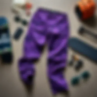 Flat lay of Rothco purple camo pants with skateboarding accessories.