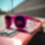 Stylish pink sunglasses resting on a skateboard