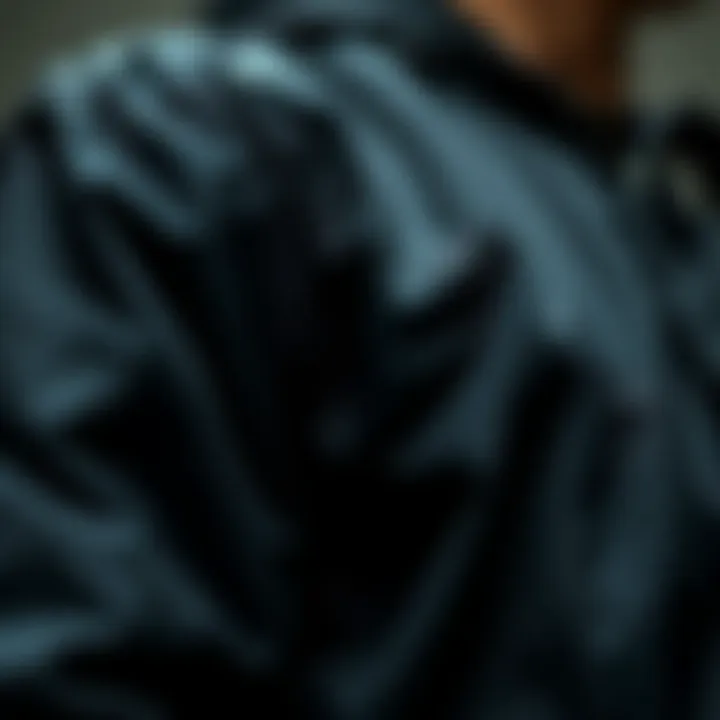 Fabric and Design Details of the Black Coach Jacket A close-up view of the black coach jacket showcasing its fabric texture and design details