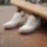 Close-up of white Vans with brown soles on a skateboarding surface